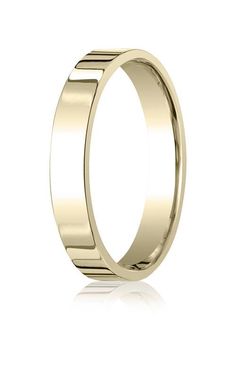 a gold wedding ring with vertical lines on the outside and inside, set against a white background