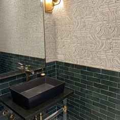 a bathroom sink sitting under a mirror next to a faucet mounted on a wall