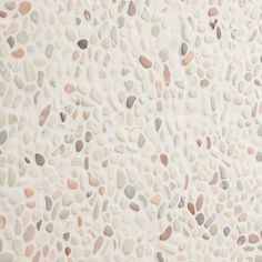 a white wall with many different colored rocks on it