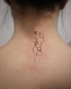 the back of a woman's neck with a small tattoo on her left side