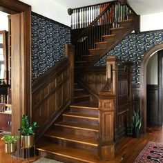 a wooden staircase in a home with blue wallpaper