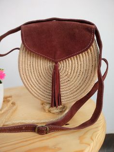 Moroccan Raffia bag is handwoven by local artisans, Raffia woman bag will be irreplaceable accessory very elegant and combines with different style. that round raffia and leather handbag have slight imperfections and shape. Made: Handmade in Morocco Materials: Raffia Palm Leaves & adjustable leather strap Width 7.9 in / 20 cm approx Height 7.9 in / 20 cm approx Depth 2.4 in / 6 cm approx Brown Handwoven Bag With Round Handle, Bohemian Brown Bags With Round Handle, Bohemian Brown Crossbody Straw Bag, Bohemian Brown Shoulder Bag With Round Handle, Bohemian Brown Natural Fiber Bucket Bag, Bohemian Brown Bucket Bag In Natural Fiber, Bohemian Brown Bucket Bag With Natural Fiber, Bohemian Natural Straw Crossbody Bag, Natural Bohemian Straw Crossbody Bag