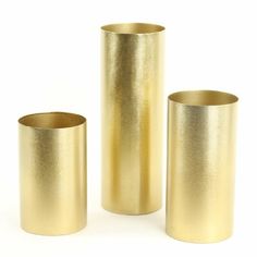 three gold vases sitting next to each other