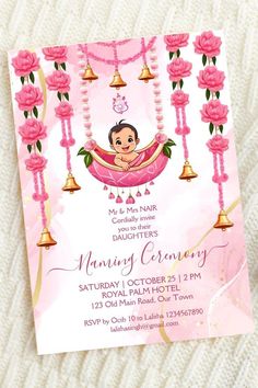 a pink and gold baby shower party with flowers on the bottom, bells hanging from it's head