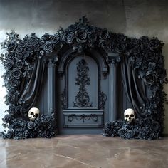 two skulls are sitting in front of a black wall with roses and scrolls on it