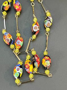 Description: This is a vintage Venetian millefiori Murano glass bead necklace. This is a gorgeous piece with colorful Venetian beads with gold tone link accents. The piece is unsigned and has a screw clasp. Condition: Vintage, pre-owned condition Measurements: The necklace measures 32 inches in length and the beads measure 0.75 inches in length. The piece has a working screw clasp. Signature: No signature Disclaimers: NOTE FOR RHINESTONE ITEMS:  All stones are inspected prior to listing and agai Vintage Czech Glass Oval Beaded Necklace, Vintage Glass Necklace With Oval Beads, Vintage Glass Necklaces With Oval Beads, Vintage Glass Beaded Necklaces With Oval Beads, Vintage Glass Beaded Necklaces With Colorful Beads, Vintage Necklace With Colorful Oval Beads, Vintage Glass Oval Beads, Retro Colorful Beads Jewelry For Jewelry Making, Retro Colorful Beads Jewelry For Making