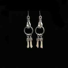 Tiny, real skunk toe bones hang from 1 inch silver plated, Victorian style hands. The small bones measure about .75 inch each.They hang from sterling silver French hook earrings.  These dainty bone earrings drop to almost 2 inches. The skunk toe bones are professionally cleaned and sterile. As with all of our natural animal products, these are harvested humanely from animals that are already deceased. None of our natural components are from animals that have been killed for the purpose of use in our jewelry, they are all by-products. This piece of jewelry is sent in a bubble pack envelope via US postal service, first class mail with insurance and comes in a gift box. International rate is $23. Buyers are responsible for any customs and import taxes that may apply. I am sorry, but Necromanc Unique Bone-colored Sterling Silver Jewelry, Unique Bone Colored Sterling Silver Jewelry, Handmade Sterling Silver Jewelry In Bone Color, Bones On Hand, Real Bone Jewelry, Animal Bone Jewelry, Taxidermy Jewelry, Hand Earrings, Angel Fashion