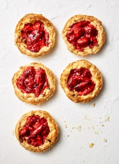 four small pies with strawberry jam on top