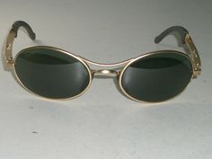 You are bidding on very gently used, stunning looking pair of VINTAGE BAUSCH & LOMB RAY-BAN W2177 G15 MATTE GOLD BIKERS ECLIPSE ORBS WRAP SUNGLASSES w/CASE. The color of impact/scratch resistant constant density glass lens is Green/Neutral Gray. Both lenses & nose pads are etched with small BL logo. OVERALL EXCELLENT/SUPERB CONDITION: SUPER CLEAR VIEW. COMES WITH A NEWER LUXOTTICA RAY-BAN CASE. Measures 5 1/4" across the hinges. Please see pictures for details & markings. Thanks for bidding!!! Vintage Gold Sunglasses With Polarized Lenses, Vintage Gold Sunglasses For Formal Occasion, Wrap Sunglasses, Easy Rider, Wayfarer Sunglasses, Sunglasses Sale, Matte Gold, Ray Ban, Sunglasses Accessories