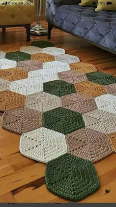 a crocheted rug is laying on the floor next to a couch and chair