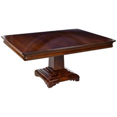 a square wooden table with two pedestals on each side and an oval shaped top