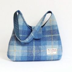 "This bag is made with genuine Harris Tweed 100% wool fabric in a blue tartan pattern. It is lined with a grey or blue cotton fabric and closes with a magnetic snap on the flap. It is fully interfaced and interlined to give it structure and durability. It has 2 pockets inside, one is fastened by a zipper. The strap is the ideal size to either carry the bag in your hand or on your shoulder. SIZE: 33cm wide x 29cm tall (13\" x 11.5\"), approx. strap: 50cm (20\") The coin purse in the picture is no Harris Tweed Bag, Macleod Tartan, Eco Friendly Handbags, Tweed Purse, Tweed Bag, Cotton House, Cork Bag, Blue Tartan, Purse Gift