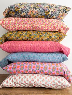 six pillows stacked on top of each other in different colors and patterns, with the text mix and match soft cotton sheets