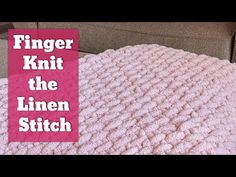 a pink knitted blanket sitting on top of a couch