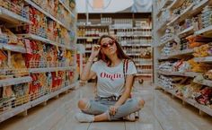 a woman sitting on the floor in a grocery store