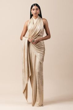 Gold pre-stitched lam  jersey metallic wrap saree. Comes with draped halter blouse.
Component: 2
Neckline: Halter
Sleeve Length: Sleeveless
Fabric: Lam  Jersey
Color: Gold
Pre-draped saree
Draped blouse
Cutout back
Closure: Blouse: Back hooks - Aza Fashions Drape Sarees, Halter Neck Blouses, Saree Wearing Styles, Draped Saree, Saree Wearing, Saree Draping Styles, Modern Saree, Draping Fashion, Saree Gown