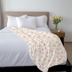 a bed with white sheets and flowers on it