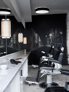 a black and white photo of a barber's chair in front of a mirror