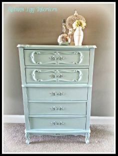 an old dresser is painted blue and has flowers on top