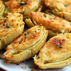 some artichokes are on a white plate with parsley sprinkled