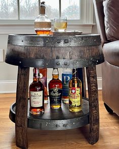 a wooden barrel table with liquor bottles on it