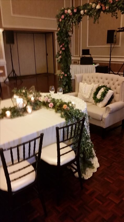 Tufted LOVESEAT with Chiavari chairs and seeded eucalyptus arch and table runner by Inside Décor Rental Dubuque IA Eucalyptus Arch, Kings Table, Tufted Loveseat, Head Tables, Wedding Backdrops, Inside Decor, Seeded Eucalyptus, Chiavari Chairs, Head Table