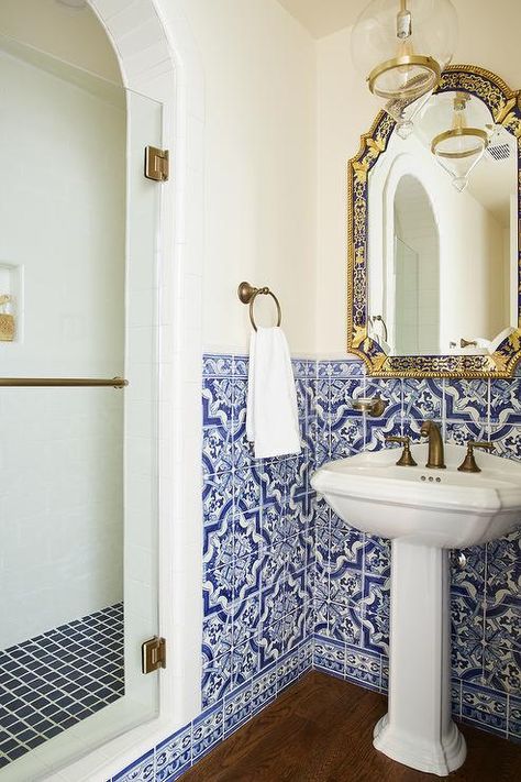 Mediterranean bathroom design boasts blue Moroccan style wall tiles surrounding a pedestal sink fitted with a dark brass faucet under an ornate blue and gold mirror. Sink Only Bathroom, Blue Moroccan Tiles Bathroom, Positano Inspired Bathroom, Greek Style Bathroom Blue And White, Bathroom Ideas Marocan Tiles, Amalfi Bathroom Ideas, Mediterian Style Bathroom, Portuguese Style Bathroom, Italy Theme Bathroom