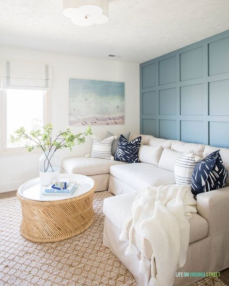 A TV room with blue board and batten grid wall with linen sectional, round coffee table and coastal wall art with a beach scene. Light Blue Grey Paint, Blue Gray Paint Colors, Blue Accent Walls, Blue Gray Paint, Diy Accent Wall, Accent Walls In Living Room, Grey Paint Colors, Wallpaper Accent Wall, Coastal Living Room