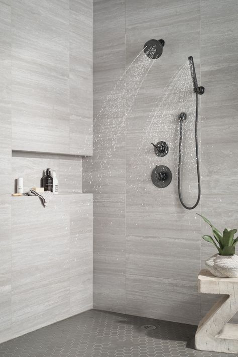 Inspired by the sleek elegance of modern European design, the Trinsic® Bath Collection completes the look of any contemporary bath, from classic to rustic. Delta® H2Okinetic® Showers look different because they are different. Using advanced technology, H2Okinetic showers sculpt water into a unique wave pattern, giving you 3X the coverage of a standard shower head.* The end result is a shower that provides more coverage, more warmth and more intensity for a truly drenching shower experience. Delt Dark Floor Light Shower Tile, Minimalist Bathroom Shower Tile, Corner Seat In Shower Ideas, Modern Walkin Shower Ideas, Black Hardware Shower, Showers With Black Fixtures, Black And White Bathroom Shower Ideas, Grey Tile Showers, Tiny Bathroom Renovations