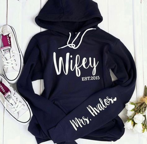 Listing is for a wifey hoodie with the sleeve print. Under the personalization box, please leave me the name for the sleeve and the Est.  Let us know if you would like the heart at the end of your last name.  Unisex hoodie sweatshirt. We suggest sizing down for a women's fit or sticking with your normal size for a loose fit.  To order the hubby sweatshirt, please order it as a custom order. Link below.   https://www.etsy.com/listing/1107549872 and order it as a custom sweatshirt.  Requesting a p Hubby Sweatshirt, Bride Hoodie, Wifey Sweatshirt, Honey Moon, Womens Hoodies, Cute Shirt Designs, Couples Hoodies, Custom Sweatshirts, Couple Outfits