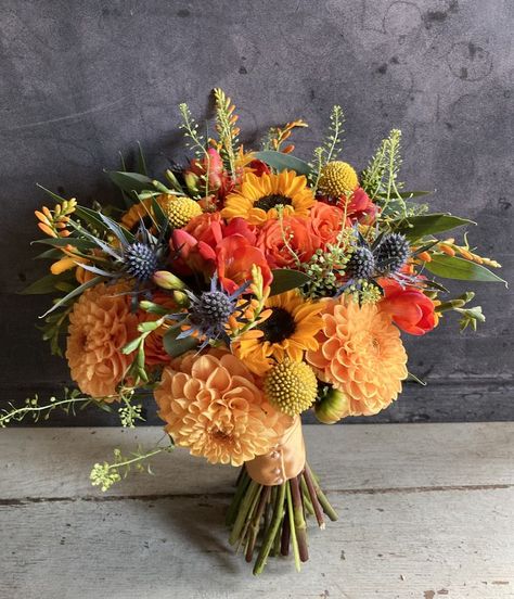 This bouquet contains the best of autumn colours and flowers! Dahlias, sunflowers, seedheads and thistles in vibrant autumn shades. Daisy Fall Bouquet, Colourful Fall Wedding Flowers, Fall Wedding Bouquets With Sunflowers Autumn Flower Arrangements, Fall Flowers With Sunflowers, Bright Autumn Color Palette Wedding, Sunflower And Marigold Bouquet, Fall Birthday Flower Arrangements, Autumn Dahlia Bouquet, Autumn Sunflower Bouquet