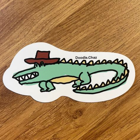 Hand drawn vinyl sticker created by myself. This cheeky cowboy croc is the sticker for you if your a fan of crocodiles with great headwear. Printed on high quality glossy vinyl that is water resistant.  Perfect for water bottles, laptops or journals. Designed, drawn and brought to life by myself. A great gift for a crocodile or cowboy lover. Follow my instagram @doodle.chaz for more designs in the future!  More designs on my shop so take a look. Each purchase will be packaged and posted in a cardboard backed envelope to ensure the sticker arrives in the best condition possible. Crocodile Doodle, Instagram Doodle, Football Stickers, Crocodiles, Follow My Instagram, Water Bottles, The Future, Vinyl Sticker, Hand Drawn