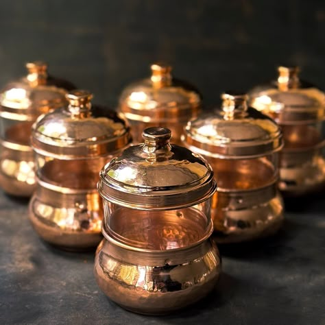 We are happy to introduce our Copper Spice Containers. These handmade Copper Spice Jars are crafted with care by skilled artisans in our workshops. Made entirely of copper, these jars not only provide a functional storage solution for your spices but also add a touch of elegance to your kitchen decor. With their versatile design, these Copper Spice Jars can be used to store a variety of spices, keeping them fresh and easily accessible.  Not only are these spice jars practical, but they also make a beautiful addition to any kitchen. The warm tones of the copper create a visually appealing display, adding a touch of sophistication to your countertop or shelf. The handcrafted nature of these jars means that each one is unique, with slight variations in color and texture that add to their char Spice Containers Ideas, Ceramic Spice Jars, Copper And Green Kitchen, Vintage Spice Jars, Copper Bowl Decor, Spice Jars Ideas, Copper Decor Accents, Tuscan Home Decor, Seasoning Jars