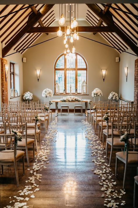 Beautiful aisle decor - white rose petals line the aisle with rose and gypsophilia bunches tied to the chairs - large displays either side of ceremony table with a long low display - nuthurst grange wedding venue - penny johnson flowers coleshill White Roses Aisle Decor, Petal Isle Wedding, Wedding Aisle Flower Petals, Rose Petal Wedding Aisle, Indoor Wedding Aisle Decor, White Rose Petals Down Aisle, Rose Petals Down Aisle, Wedding Isles Ideas, Wedding Aisle Petals