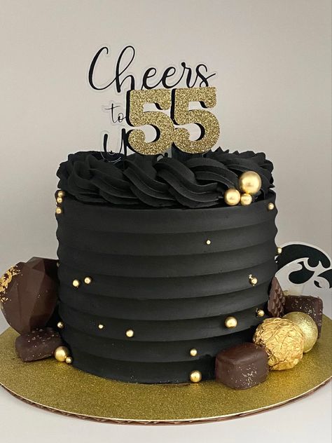 Black buttercream cake decorated with gold balls, chocolates and a cake truffle heart Birthday Cakes For Men Black And Gold, Black Buttercream Cake For Men, Black Gold Cake Men, Black And Gold 40th Birthday Cake, Black And Gold Cakes For Men, Black And Gold Buttercream Cake, Black And Gold 50th Birthday Cake, Black Gold Cake Birthday, Black Cake For Men