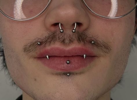 DARE TO BE DIVINE 🪽  ANGEL FANGS BY @vivipiercings   Soho, Union Square, and Williamsburg  11AM-9PM 7 DAYS A/W🕘 WALK-INZ OR BOOK ONLINE..📕 TATTOOS & PIERCINGS, NO ATTITUDE, NO MISERABLE HOOPS TO JUMP THROUGH....🚫  WALK-INZ WELCOME OR BOOK ONLINE AT  ⚔️livebytheswordtattoo.com⚔️ . . . . #angelfangs #angelbites #lippiercing #piercer #williamsburg #brooklyn Face Peircings Guys, Angel Bites And Vertical Labret, Unique Lip Piercings, Male Facial Piercings, Goth Face Piercings, Nose Piercing Men Septum, Vertical Labret Piercing Men, Mens Industrial Piercing, Cool Facial Piercings