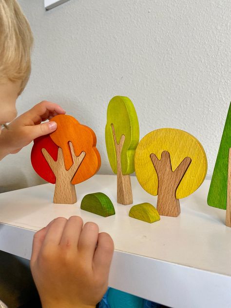 These handmade trees are perfect for building forests and cities and reimagining fairy tales. This set of hand-made wooden trees will be a wonderful addition to any nature table or play space and fit perfectly into any Montessori playtime! They are fun and colorful seasons! The set includes 4 trees & 2 bushes. Each tree comes in 2 parts, the largest tree comes in 3. CARE: Can wash with soapy water and a damp cloth Dry immediately Do not submerge in water Do not use disinfectant or hot water