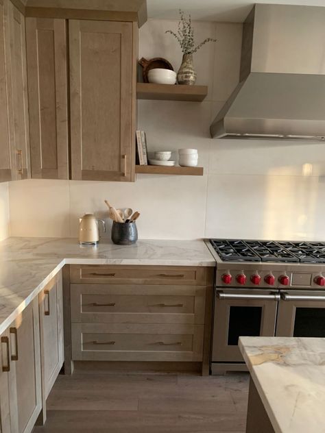 Floating Shelves By Stove, Natural Wood Kitchen Cabinets With Stainless Steel Appliances, Natural Wood Kitchen Cabinets Gray Floor, Kitchen Cabinet Panels Ideas, Natural Wood Tone Kitchen, Organic Looking Kitchen, Alaska Kitchen Design, Organic Modern Countertops, Organic Modern Kitchen Shelves