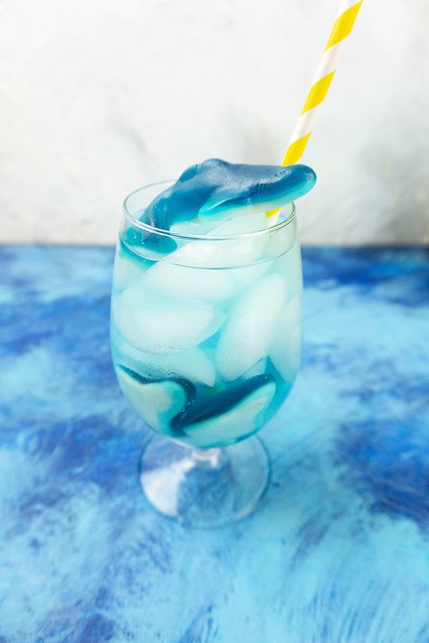 This refreshing summer drink is perfect for kids. Blue Gatorade and 7-Up are mixed together with some ice and shark gummies to look just like the ocean. Make this fun, easy DIY drink recipe today!#sharkweekrecipes #sharkfizzydrink #kidfriendlydrink #mocktailrecipes #sharkweek Shark Gummies, Shark Week Recipes, Blue Gatorade, Gummy Sharks, Kid Friendly Drinks, Blue Drinks, Diy Drinks, Refreshing Summer Drinks, 7 Up