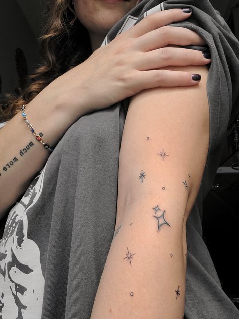 Star tattoo on arm Sparkle Tattoo Sleeve Filler, Scattered Star Tattoos, Star Patchwork Tattoos, Stars Around Moon Tattoo, Thigh Star Tattoo, Star Arm Band Tattoo, Star Hip Tattoos Women, Stars Wrapped Around Arm Tattoo, Star Band Tattoo