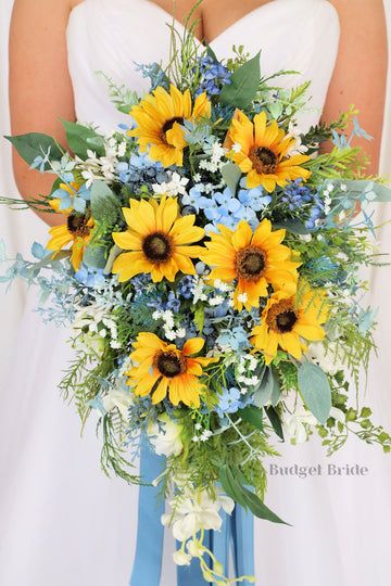 Sunflower Bouquet With Blue Flowers, Sunflowers And Seashells, Dahlias Bouquet Wedding, Blue Flowers And Sunflowers, Sunflower Cascade Bouquet, Sunflower With Blue Flowers, Bouquets For Blue Dresses, Sunflower And Dusty Blue Bouquet, Blue Yellow Green Flower Arrangements