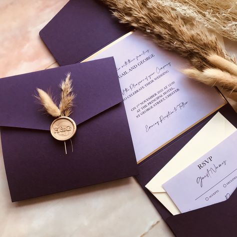 Personalised Wedding invitations with beautiful purple matte pocketfolds, wax seals, bunny tails and dried flowers! The elegant design is paired with white shimmer envelope. Format: Pocket Fold, Shape: Square, Colour: Purple pocket and white shimmer envelopeChoosing 'Say It With Print' will mean your laser cut invitation pockets and envelopes will arrive in style in a beautiful white presentation box.Items included: Purple Pocket, Gold Mirror Backer, Lilac Insert Cards, Gold Initials Wax Seal, B Bunny Tails Wedding, Gold Wedding Invitations Elegant, Plum Wedding Invitations, Envelope Format, Dark Purple Wedding, Witch Store, Fancy Envelopes, Purple And Gold Wedding, Purple Invitations