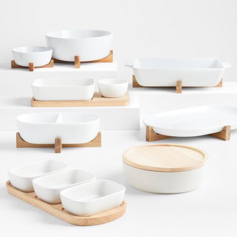 Our oven-to-table serving pieces are as smart as they are stylish, and this lidded serving bowl is no exception. Safe for use in the oven, the stoneware bowl bakes casseroles, warms soups and bakes seven-layer dip. The solid wood lid, a beautiful counterpoint to the sleek white ceramic, keeps contents warm or serves as a trivet to protect tables and countertops from the hot bowl. Our oven-to-table round serving bowl with lid is a Crate and Barrel exclusive.    Stoneware and solid wood   60-oz. c Crate And Barrel Serving Platters, Hosting Platters, Simple Table Setting Ideas, Crate And Barrel Kitchen, White Serving Dishes, Table Bowl, Serving Dishes Set, Serving Bowls With Lids, Baking Dish Set