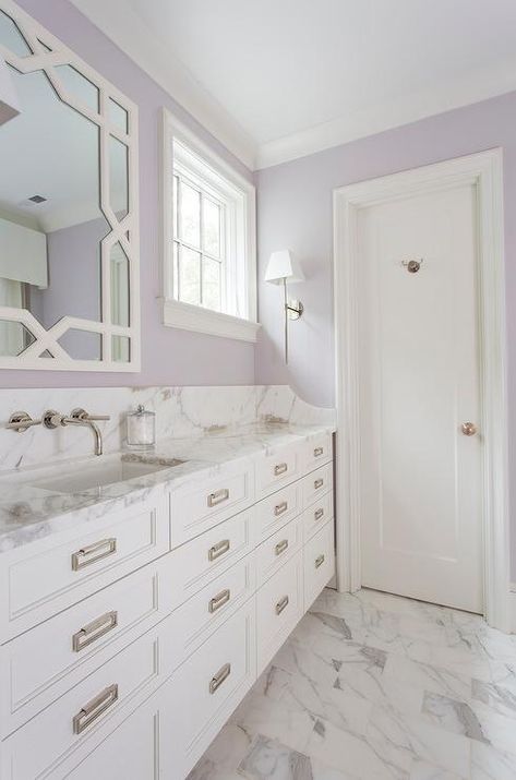 White and Lavender bathroom boasts a white trellis mirror, lining a lavender painted wall, placed over an extra-wide single washstand fitted with stacked drawers adorned with rectangular drop pulls topped with gray and white marble. Lilac Bathroom, Lavender Bathroom, Marble Paint, White Trellis, Purple Bathrooms, Bathroom Paint Colors, Marble Painting, Bathroom Color, Upstairs Bathrooms