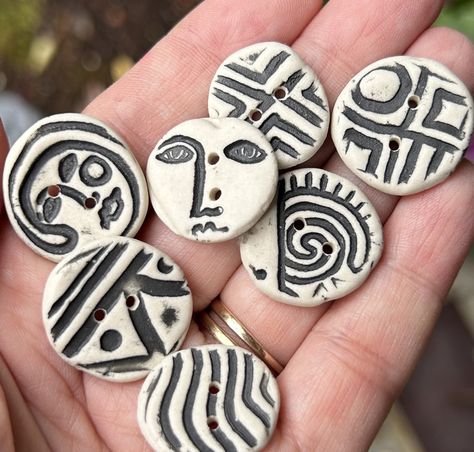 "Handmade Pottery Buttons- Porcelain Buttons-Unique Buttons I made each of these unique, one of a kind, button sets  by hand from raw porcelain clay which I embossed with a unique design, and added black glaze to the embossed design which contrasts with the natural ivory white colour of the porcelain. They have been fired to 2250F (stoneware hardness) in my kiln and they are quite robust.  These funky buttons will add a whimsical touch to a special project and more buttons can be added if you need to enlarge your set and sets can also be combined. There are 12 different sets to choose from (scroll through the photos to see all available sets).   I can add single buttons if you need a larger set.  Send me a message and I will send you pictures of options to add on to your set BUTTON SIZES ( Ceramic Buttons Handmade, Pottery Buttons, Porcelain Buttons, Clay Buttons, Unique Buttons, Ceramic Buttons, Black Glaze, Embossed Design, How To Make Buttons