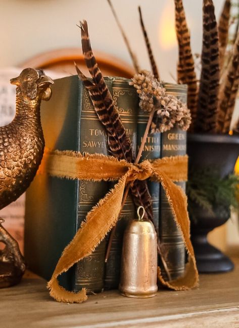 green vintage books tied with a velvet ribbon Fall 2023 Vintage, Book Mantle Decor, Anthropology Decor Inspiration, Vintage Elegant Christmas, Vintage New Years Decor, Velvet Fall Decor, Decorating With Pheasants, Pheasant Fall Decor, Decorating With Pheasant Feathers