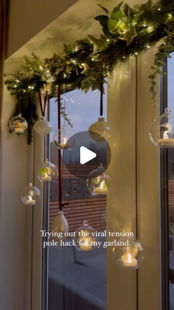 23K views · 1.2K likes | Ashley | Home Interiors, Garden & DIY on Instagram: "Anyone else still adding to their Christmas decorations? I decided on a whim to add my hanging tea lights to the windows this year rather than above my dining room table. So I grabbed one of those tension poles and wrapped it with left over garlands and baubles. I hung them using clear wire to give them a floating effect. The remote comes in so handy to turn the tea lights on/off. 

Tension pole from @dunelmuk 

#diningroom #christmasdinnertable #christmasfaffing" Hanging Christmas Decor Over Dining Table, Hanging Candles Christmas, Above Window Christmas Decor, Garland Above Window, Tension Rod Christmas Garland, Christmas Window Garland, Window Garland Christmas, Window Garland, Hanging Tea Lights