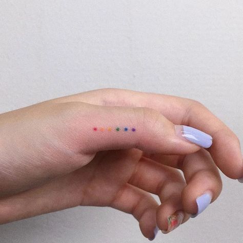 70+ unique and striking finger tattoo designs: symbols, hennas, roses, snakes, dots, lettering, hearts, and wedding rings for couples. Bonus: tattoo meanings. Colour Finger Tattoo, Mini Rainbow Tattoo, Little Rainbow Tattoo, Lgbtq Tattoos Ideas, Subtle Pride Tattoo, Rainbow Tattoo Ideas, Lgbtq Tattoos, Tiny Tattoos For Women, 16 Tattoo