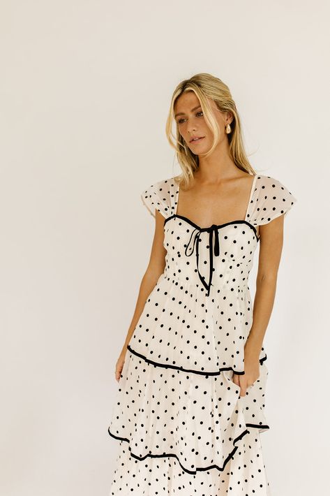 the retro-inspired dress of our dreams. it features sheer short sleeves, a ribbon tie bodice, + dainty ruffle details. both sweet + sophisticated, this off-white + black polka dot midi dress is perfect for fancy dinner dates, holiday parties, + anytime you’re feelin’ frilly. off white + black polka dots // midi length, sweetheart neckline, sheer polka dot sleeves, back zipper closure, tiered skirt, lined model is 5'8" + wearing a small measurements are approximate + taken while laying flat xsmal Cute Dresses Photoshoot, Polka Dot Cocktail Dress, Polka Dot Bridesmaid Dresses, Polka Dot Bridesmaid Dress, Church Dresses Fall, Fun Midi Dress, Polka Dot Dress Black And White, Outfit Ideas With Dresses, Fall Dresses 2024