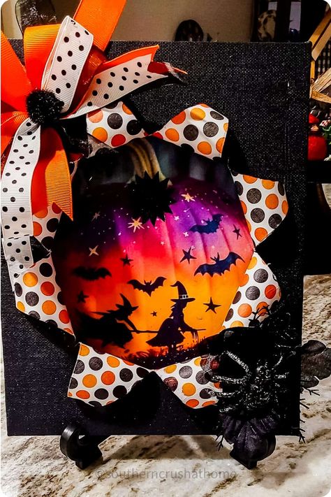 Halloween-themed decoration featuring a starburst design with bats, witches, and a spider, accented with polka dot and orange ribbons. Breakout Canvas Craft, Halloween Busted Canvas Ideas, Break Out Canvas, Halloween Busted Canvas Diy, Halloween Canvas Art Ideas, Busted Canvas Crafts Halloween, Halloween Busted Canvas, Bust Out Canvas Diy, Busted Canvas Art